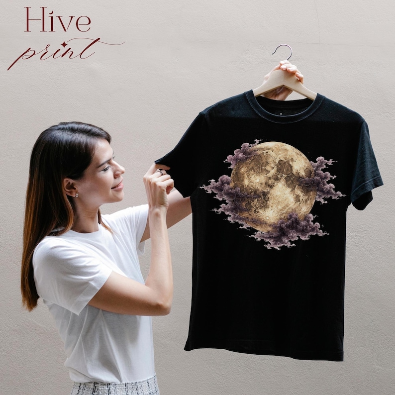 May include: A black short-sleeved t-shirt featuring a graphic print of a full moon surrounded by dark purple clouds. The text Hive print is visible in the upper left corner of the image. The garment has a crew neckline and a standard fit.