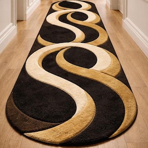 May include: A long, oval-shaped runner rug with a repeating abstract design. The rug features a dark brown background with cream and gold-colored swirling patterns. The rug is placed on a light-colored wooden floor in a hallway.
