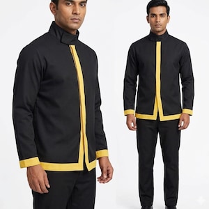 以下が含まれることがあります： 黒い長袖シャツ、マンダリンカラーと黄色のトリム付き。 シャツは前面に垂直の黄色のストライプと袖口に黄色のトリムが付いています。 黒いパンツと合わせています。