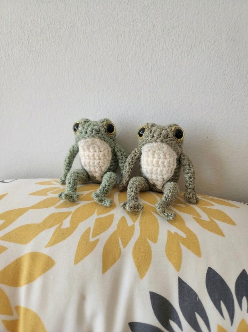 Crochet frog pattern - 2 crocheted frogs sitting on a sofa