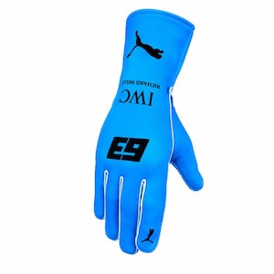 Peut inclure: Un gant de course bleu vif arborant le logo Puma noir au poignet et sur le bout des doigts, le numéro 63 en noir, ainsi que le texte noir IWC et RICHARD MILLE imprimé sur le dos. Le gant présente un passepoil blanc le long des coutures.