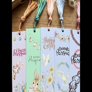Può includere: Set di sei segnalibri a tema pasquale con nappe colorate. Ogni segnalibro presenta illustrazioni di coniglietti, uova e motivi floreali, con le parole "Buona Pasqua" e "Happy Easter".