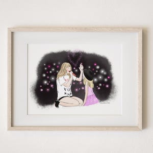 May include: A framed illustration of two women, one holding a microphone and the other giving a high five. The background is a dark blue with pink and white lights. The text on the shirt of the woman holding the microphone says "It's the Mom".