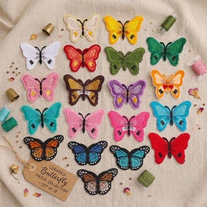 May include: A collection of nineteen embroidered butterfly patches in various colours including red, blue, yellow, pink, green, and orange. A brown paper tag with the text Curated Butterfly Patch Collection - Set of 19 is included.