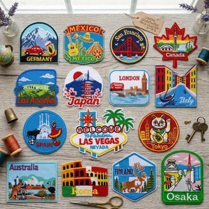 May include: A collection of sixteen embroidered travel patches featuring various global landmarks and cities including Germany, Mexico, San Francisco, Canada, Los Angeles, Japan, London, Italy, Spain, Las Vegas, Tokyo, Australia, Roma, Finland, and Osaka.