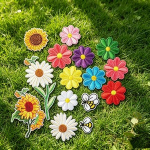 Puede incluir: Una colección de parches de tela bordados que representan varias flores, incluyendo girasoles, margaritas y flores coloridas en rojo, rosa, morado, azul y amarillo, junto con dos pequeños parches de abejas con alas blancas y cuerpos amarillos.