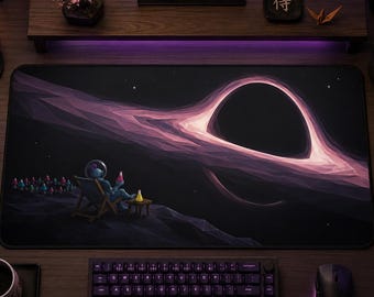 May include: A rectangular desk mat featuring a low-poly space illustration of an astronaut sitting in a lounge chair, observing a large black hole with glowing pink and purple light streaks against a dark starry background on a wooden desk.