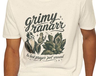 May include: A cream-colored short-sleeve t-shirt featuring a graphic print of a bearded figure with glasses holding a potion bottle next to a cluster of crystals. The text reads grimy ranarr and the best prayer 'pot' around in dark lettering.