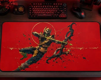 May include: A rectangular desk mat featuring a vibrant red background with a central illustration of a warrior in dark armor aiming a bow and arrow. The warrior is surrounded by a golden circular halo and dynamic black and gold paint splatter effects.