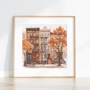 May include: A framed print featuring a watercolor illustration of New York City brownstones in autumn. The buildings are various shades of brown and beige, with fire escapes and trees with orange leaves. A person walks on the sidewalk.