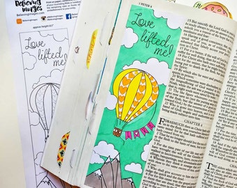 May include: A printable Bible art bookmark featuring a hot air balloon with hearts and the text "Love Lifted Me!" The balloon is flying over mountains and clouds against a turquoise background. The bookmark is designed to be colored in.