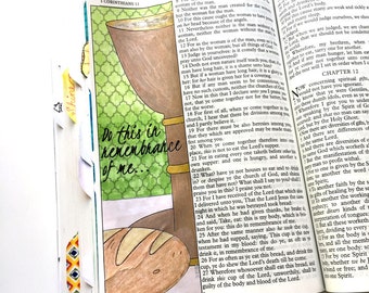 May include: A hand-drawn bookmark with a chalice, bread, and the text "Do this in remembrance of me." The bookmark is placed in a Bible, with the words "Holy Communion" at the top.