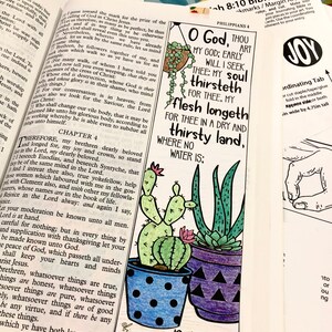 May include: A Bible art page featuring a colourful illustration of two potted succulents. The text "O God, Thou My God; Early Will I Seek Thee: My Soul Thirst For Thee, My Flesh Longeth For Thee In A Dry And Thirsty Land, Where No Water Is; Psalms 63:1" is printed on the page.
