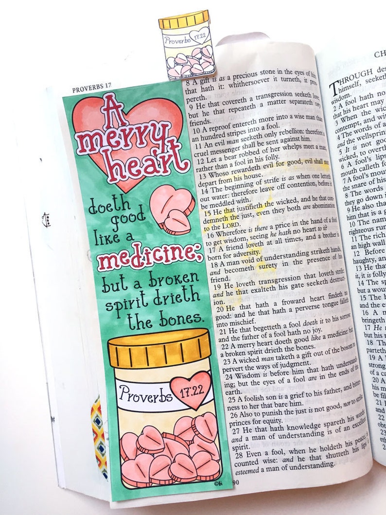 May include: A hand-drawn illustration of a heart with the words "A merry heart doth good like a medicine: but a broken spirit drieth the bones." The illustration is surrounded by a green border and a yellow pill bottle with pink hearts inside. The text "Proverbs 17:22" is written on the bottle.