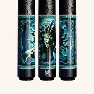 Könnte beinhalten: Ein schwarzes Billard-Queue mit einer detaillierten Grafik von Medusa mit leuchtend grünen Augen und Schlangen als Haar. Das Design umfasst einen türkisfarbenen Rand mit griechischem Mäandermuster und das weiße UNI-Logo am Ende. Strukturierter Griff.