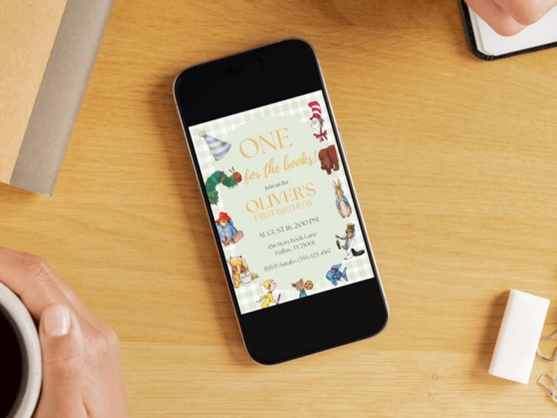 May include: A smartphone displaying a digital invitation for a first birthday party. The invitation features a light green gingham background with illustrations of storybook characters and text reading ONE for the books! Join us for OLIVER'S FIRST BIRTHDAY.