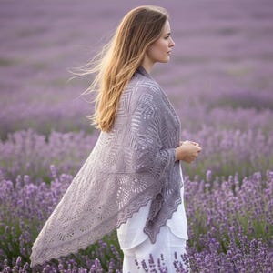May include: A woman wearing a gray, open-weave shawl stands in a field of lavender. The shawl has a geometric pattern on the shoulders and a scalloped edge. The woman is wearing a white top and has long, blonde hair.