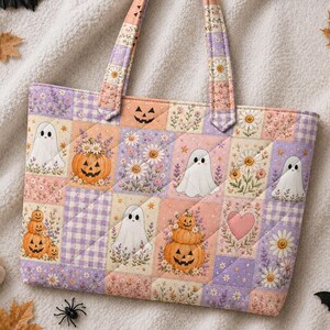 May include: A quilted tote bag featuring a patchwork pattern of pastel squares with illustrations of white ghosts, orange jack-o'-lanterns, daisies, lavender sprigs, and pink hearts. The bag has two matching fabric handles and a rectangular shape.
