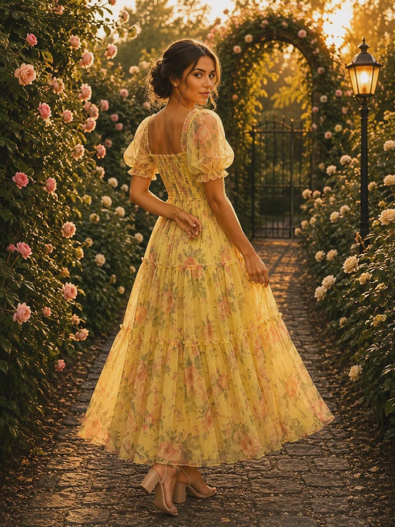 May include: A yellow midi dress featuring a square neckline, puff sleeves, and a smocked bodice. The dress is made of a sheer, layered fabric with a pink and green floral print, a tiered skirt, and a flared silhouette that falls below the knees.