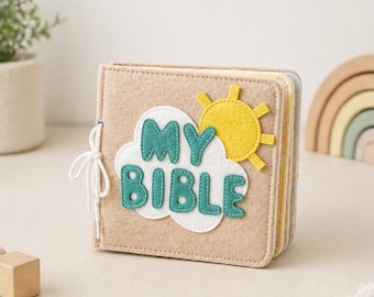May include: A square felt book with a tan cover featuring a white cloud applique, a yellow sun, and the teal text "MY BIBLE" stitched on the front. The book is bound with a white cord on the left side and contains multiple pages of varying colors.