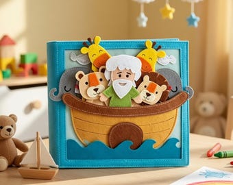 May include: A felt book with a blue cover and a scene of Noah's Ark. The ark is a brown boat with felt animals and Noah. The background is light blue with felt waves. A wooden sailboat and teddy bear are in the foreground.