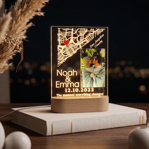May include: A personalized LED night light with a map design and a photo of a couple. The light displays the names "Noah & Emma" and the date "12.10.2023". The text "The moment everything changed" is also included.