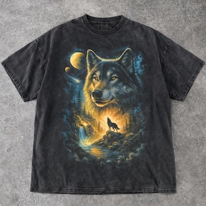 Puede incluir: Camiseta gris oscuro con un gráfico detallado de un lobo con ojos amarillos, un lobo aullando, una cascada y una luna. El diseño está ambientado sobre un fondo de bosque y cielo nocturno.