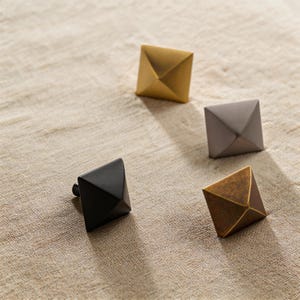 Könnte beinhalten: Eine weiße Keramik-Tasse mit schwarzem Henkel und dem Text "But First, Coffee" in schwarzer, handschriftlicher Schrift. Die Tasse steht auf einer weißen Oberfläche.