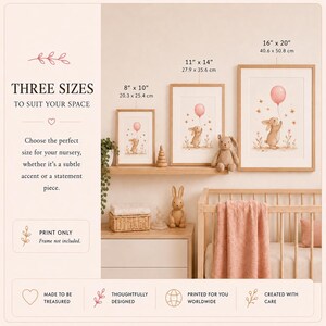 May include: Three framed wall art prints featuring a beige bunny holding a pink balloon, available in sizes 8 x 10 inches, 11 x 14 inches, and 16 x 20 inches. The prints are displayed on a wooden shelf above a crib with a pink blanket.