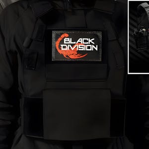 Könnte beinhalten: Eine schwarze taktische Weste mit einem rechteckigen Aufnäher, der den Text "BLACK DIVISION" in weißer Schrift sowie eine rote Skorpiongrafik zeigt. Die Weste verfügt über mehrere modulare Taschen und Riemen, mit einem Inset, das die Ausrüstung zeigt.
