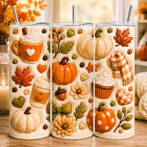 Puede incluir: Un vaso cilíndrico con base color crema que presenta iconos otoñales en relieve tridimensional, incluyendo calabazas naranjas y blancas, hojas de arce, una taza de café, un cupcake, una bufanda a cuadros y un corazón, con una pajita de metal.