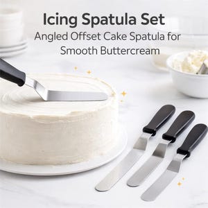 May include: An angled offset cake spatula set with black handles and stainless steel blades. The image shows the spatulas next to a frosted cake. Text on the image reads "Icing Spatula Set" and "Angled Offset Cake Spatula for Smooth Buttercream."