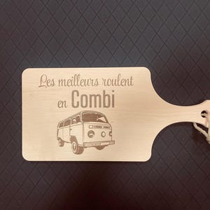 Peut inclure: Planche à découper en bois avec une poignée et une corde pour suspendre. La planche présente une image gravée d'un van vintage et le texte "Les meilleurs roulent en Combi."