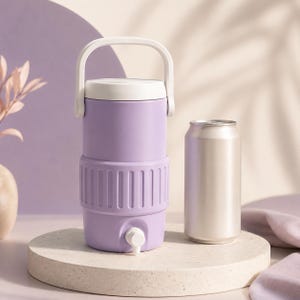 May include: A lilac-colored water cooler with a white handle and lid, next to a silver can. The cooler has a spigot and a ribbed design around the middle. The cooler is on a round, light-colored pedestal.