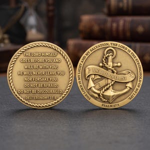 May include: Two circular brass-colored metal coins with rope-textured borders. One coin displays the text Deuteronomy 31:8, while the other features an anchor wrapped in rope with a banner reading Anchored in Christ and the text Psalm 27:1.