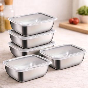 Può includere: Contenitori per alimenti in acciaio inossidabile con coperchi in plastica trasparente. I contenitori rettangolari sono impilati su un piano di lavoro colorato chiaro. Ideali per la conservazione degli alimenti.