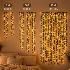 May include: Decorative string lights with green ivy leaves and warm white LED lights. The image shows three different lengths: 2M with 20 LEDs, 5M with 50 LEDs, and 10M with 100 LEDs. The lights are hanging on a wall above a bed.