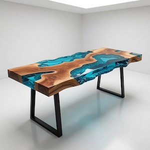 Puede incluir: Una mesa de comedor rectangular que presenta un tablero de madera natural con borde irregular y veteado prominente, integrado con un río de resina azul vibrante y translúcida en el centro, sobre dos patas de metal negro en forma de U.