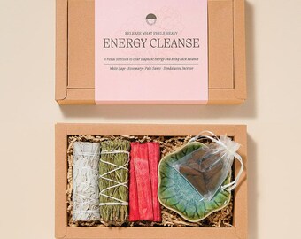 May include: A rectangular cardboard box set labeled Energy Cleanse containing white sage, rosemary, and red palo santo bundles, a green ceramic leaf-shaped dish, and a small organza bag filled with brown sandalwood incense cones.