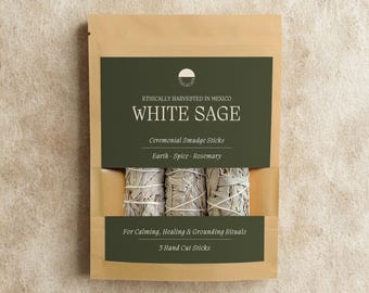 May include: A tan paper pouch containing three white sage ceremonial smudge sticks. The dark green label reads: Ethically Harvested in Mexico, White Sage, Ceremonial Smudge Sticks, Earth, Spice, Rosemary, For Calming, Healing & Grounding Rituals, 5 Hand Cut Sticks.