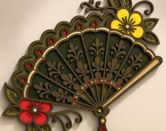 May include: A layered wooden wall art piece shaped like a folding fan. The design features dark green panels with intricate cut-out floral patterns, accented by a bright yellow flower at the top right and a vibrant red flower at the bottom left.