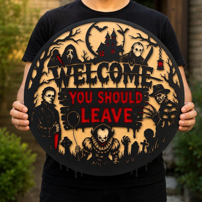 May include: A circular black and beige wooden sign featuring the text WELCOME YOU SHOULD LEAVE in red and black. The design includes layered silhouettes of horror movie characters, a haunted house, bats, trees, and tombstones in a dark theme.