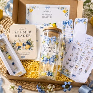 Könnte beinhalten: Eine Geschenkbox für Sommerleser mit einem Glastrinkbecher mit Bambusdeckel, einem Perlen-Schlüsselanhänger, einem Stift, einem Stickerbogen und Karten. Die Artikel zeigen blaue Schleifen, gelbe Zitronen und weiße Blumen mit dem Text "Hello Summer Reader" und "Books & Sunshine".