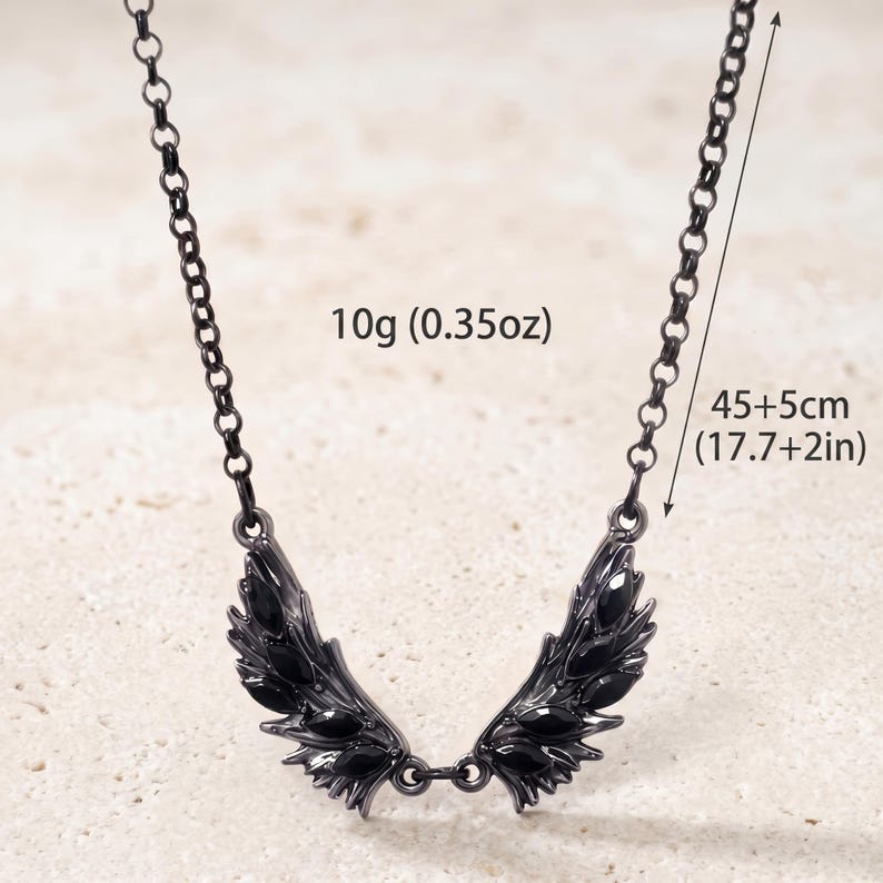 Puede incluir: Collar negro con colgante de ala. El collar mide 45+5cm de largo y pesa 10g. El colgante presenta un dise&ntilde;o de ala detallado con detalles en negro. La cadena es oscura y de eslabones.