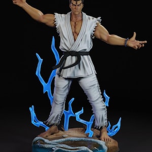Può includere: Statuetta dettagliata di una figura muscolosa in uniforme bianco di arti marziali con cintura nera. La figura è in posa con le braccia tese, circondata da effetti di fulmini blu. La base presenta una spiaggia sabbiosa e acqua.