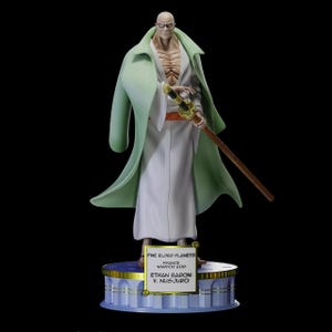 May include: A detailed figurine of a bald character wearing a white robe and a light green overcoat, holding a sword. The figurine stands on a decorative base with text that reads "FIVE ELDER PLANETS FINANCE WARRIOR GOD ETHAN BARON V. NUSJURO."