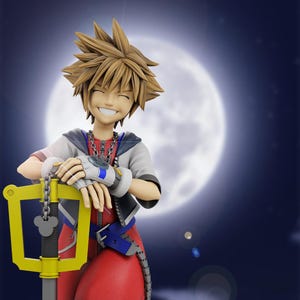 May include: A smiling figurine of a character with spiky blonde hair, wearing a red and white outfit, and holding a large yellow key-shaped weapon. The background features a large, bright moon against a dark blue sky.