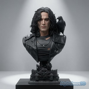 Puede incluir: Un busto detallado de una persona con cabello largo y oscuro, vistiendo una chaqueta negra sobre una camiseta desgastada con un collar de media luna. Un cuervo negro se posa en el hombro. La base muestra el texto THE CROW y IN MEMORY OF BRANDON LEE.