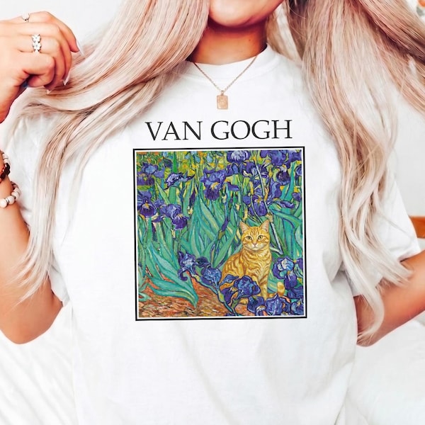 Puede incluir: Camiseta blanca con estampado de un gato en un campo de lirios, inspirada en el arte de Van Gogh. El texto "VAN GOGH" está impreso encima de la obra de arte. La camiseta es de material suave.