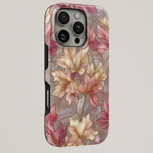 May include: A phone case featuring a floral design of stylized autumn leaves in shades of pink, cream, and gold. The leaves are arranged against a pearlescent background. The case has a glossy finish and a black side.